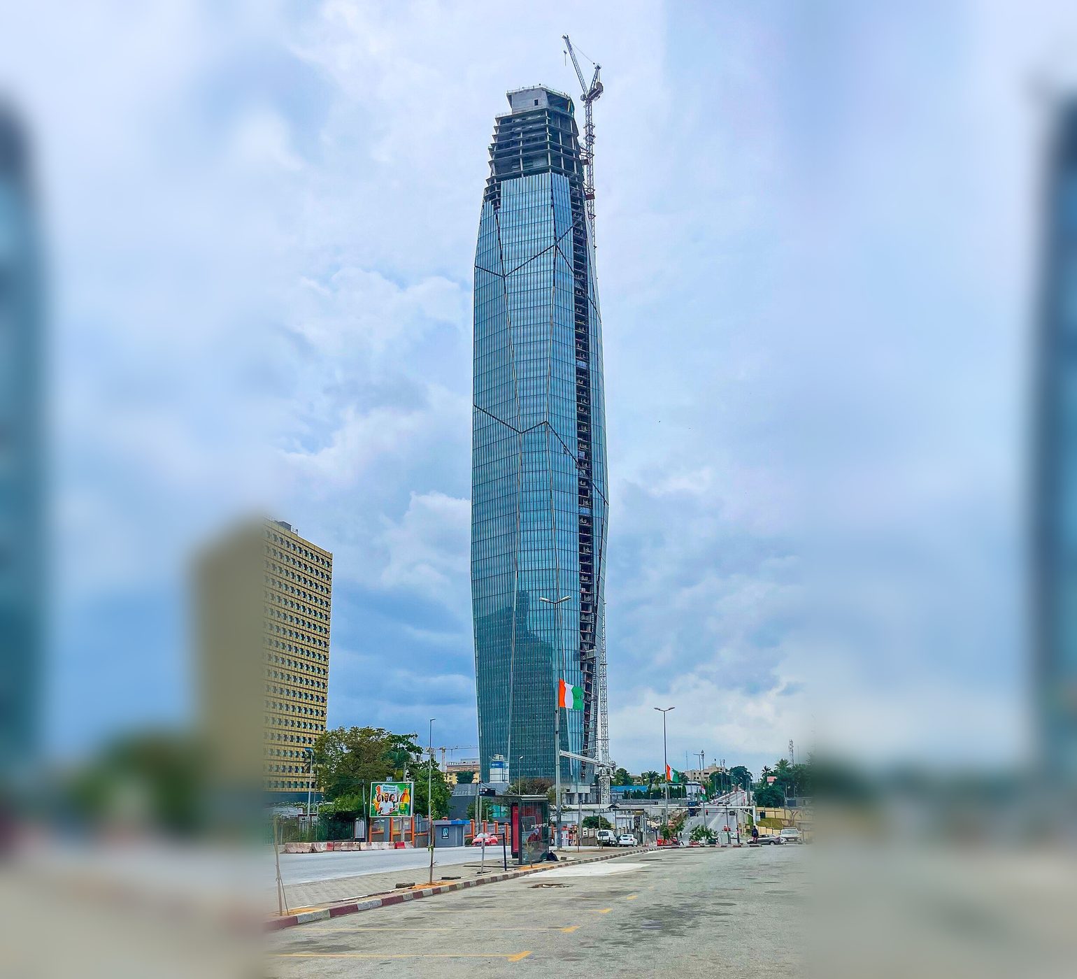 Tour F, a tall glass tower, under construction in Abidjan